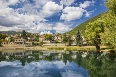 Scenic view of lake by trees against sky