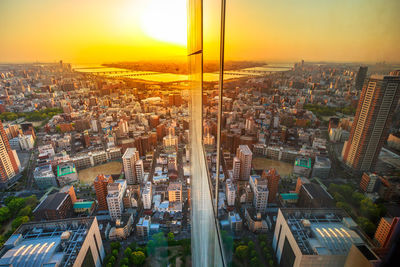 High angle view of modern buildings against sky during sunset