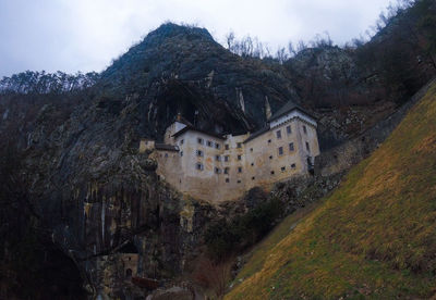 House amidst trees and buildings against sky