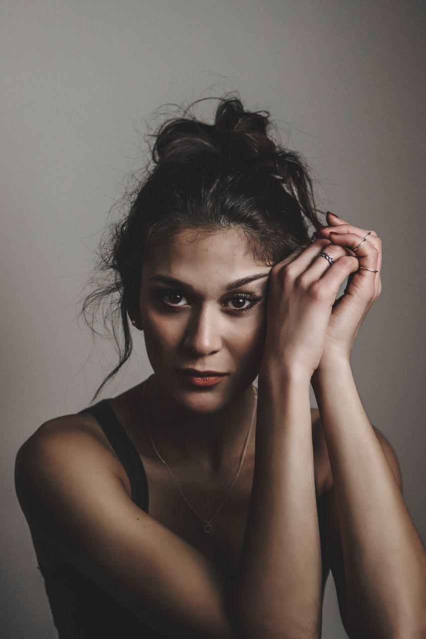 portrait, one person, indoors, studio shot, looking at camera, front view, headshot, young adult, young women, lifestyles, gray background, beauty, hair, beautiful woman, gray, women, wall - building feature, hairstyle, leisure activity, human face