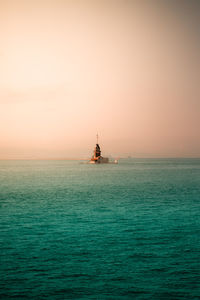 Sailboat sailing on sea against clear sky