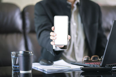 Midsection of man using laptop on table