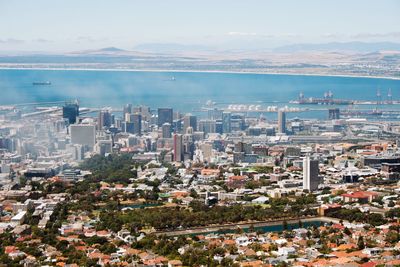 High angle view of cityscape by sea against sky