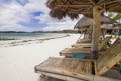 Bamboo deck chair at tanjung ann beach, kuta mandalika, lombok. scenic view of beach against sky