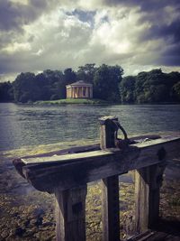 Built structure by lake against sky