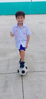 Portrait of boy playing soccer at beach