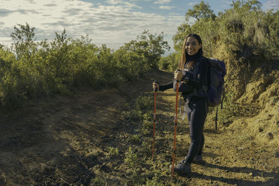 Portrait of young woman standing on field