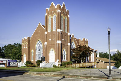 Exterior of temple against building in city against clear sky