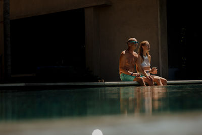 Couple sitting at pool side