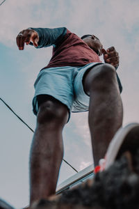 Low angle view of a young adult against sky