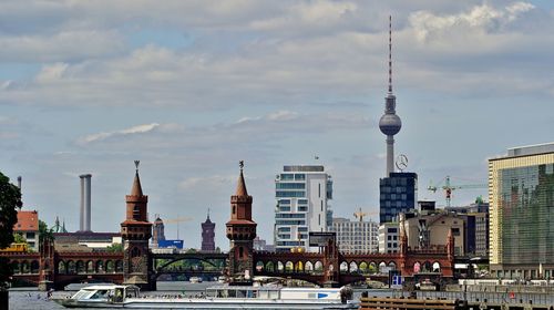 Buildings in city against cloudy sky