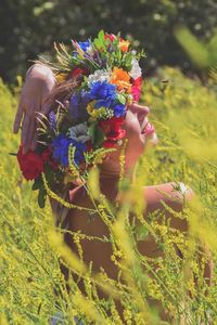 Woman holding flowers in field