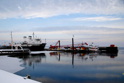 Ship moored at harbor against sky