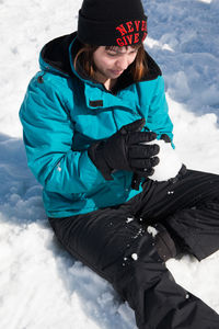 Woman holding snowball on snowy mountain