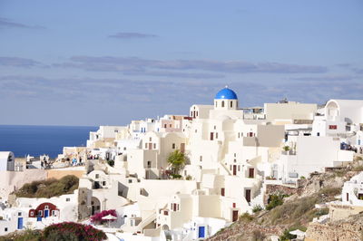 High angle view of town by sea against sky