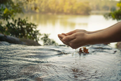 Cropped hands over river