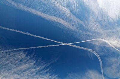 Low angle view of vapor trail in blue sky