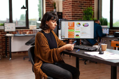 Businesswoman using mobile phone in office