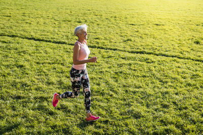 Senior woman running on rural meadow