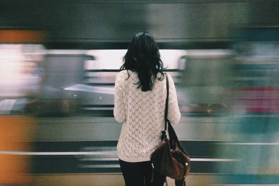 Blurred motion of woman standing on wall