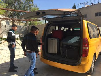 People standing by car on road
