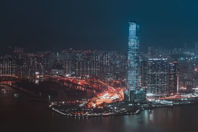 Illuminated buildings in city against sky at night