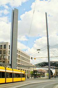 Cars moving on road against cloudy sky