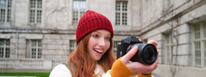 Young woman photographing through mobile phone