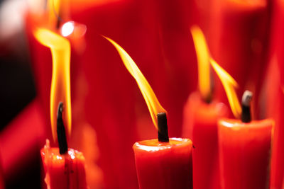 Rows of burning red candles are used in religious prayers