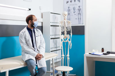 Doctor wearing mask sitting in clinic