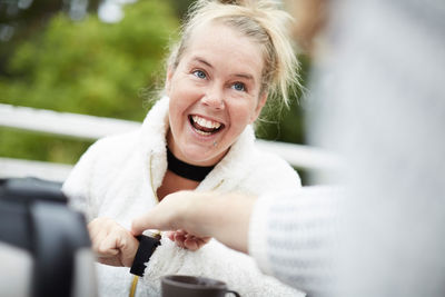 Cropped image of male caretaker adjusting time on wristwatch of disabled woman in backyard