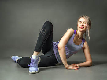 Portrait of young woman sitting on floor