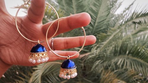 Close-up of hand holding decoration hanging on plant