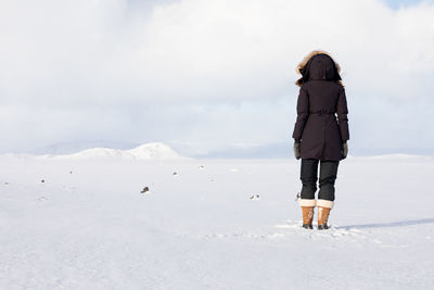 Rear view of man standing on snow covered land