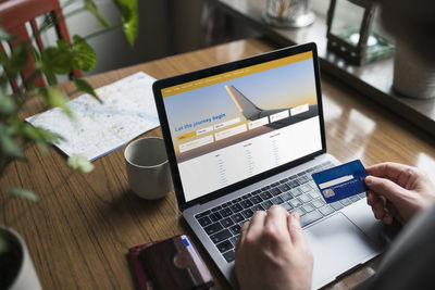 Man searching for flights on laptop and holding credit card