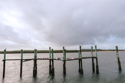 Wooden fence on field against storm clouds