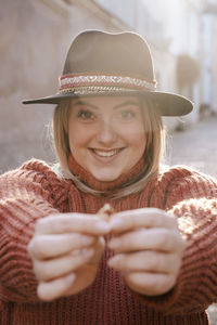 Portrait of smiling young woman holding ring 