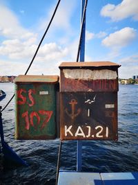 Text on rusty ship against sky