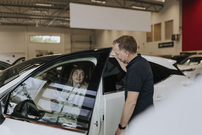 Salesman and female customer in car dealership