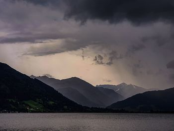 Scenic view of lake and mountains against sky during sunset