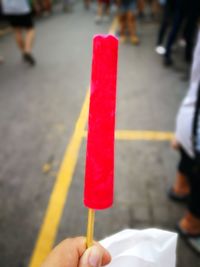 Close-up of hand holding red umbrella