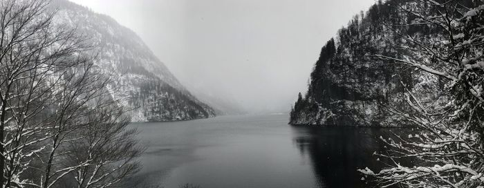 Scenic view of river by mountains during winter