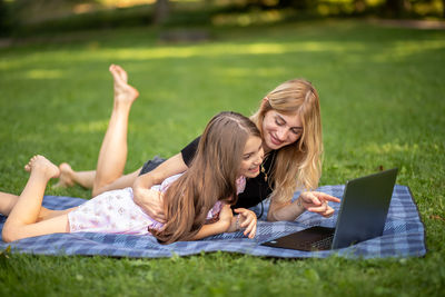 Side view of young woman using laptop at park