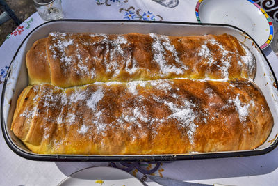 A dish with freshly baked homemade poppy seed cake is placed on the kitchen table. 