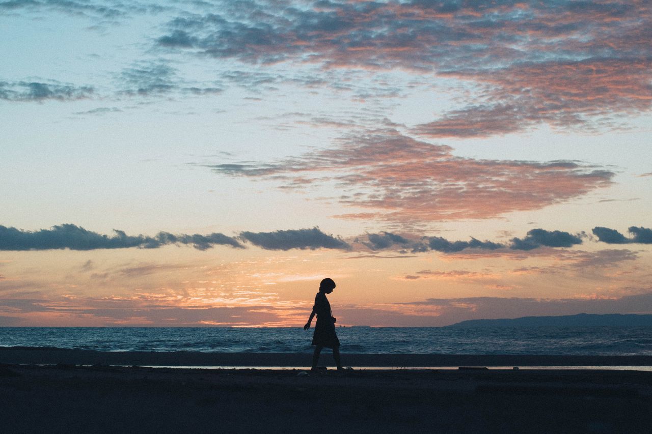 SILHOUETTE OF MAN STANDING ON BEACH