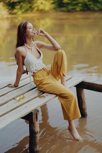 Young woman sitting on pier