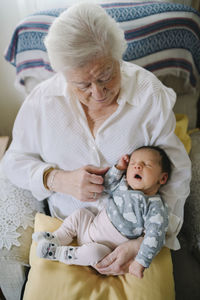 Great grandmother taking care of her great granddaughter at home