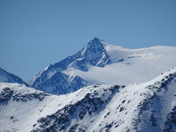 Scenic view of snowcapped mountains against clear blue sky