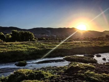 Stream flowing against bright sky at morning