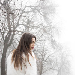 Beautiful young woman in fur jacket during foggy weather